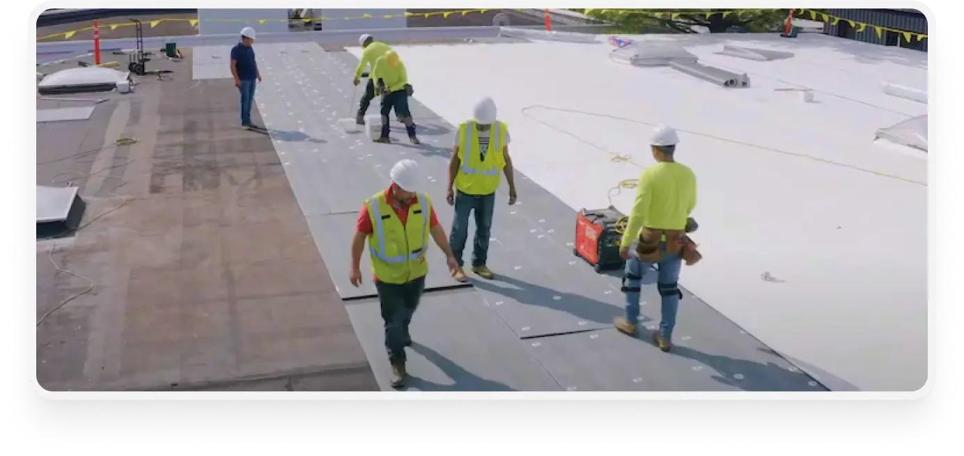 people working on a roof of a commercial building - commercial roofing repair