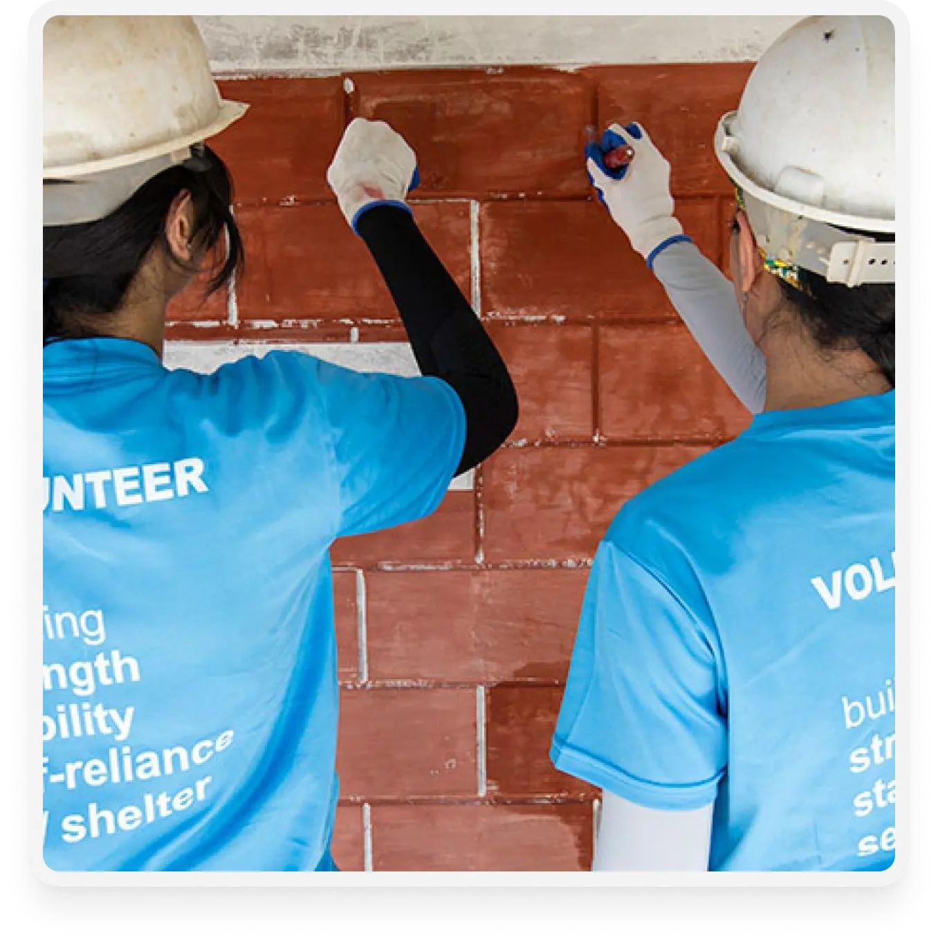 an image of volunteers painting a brick wall